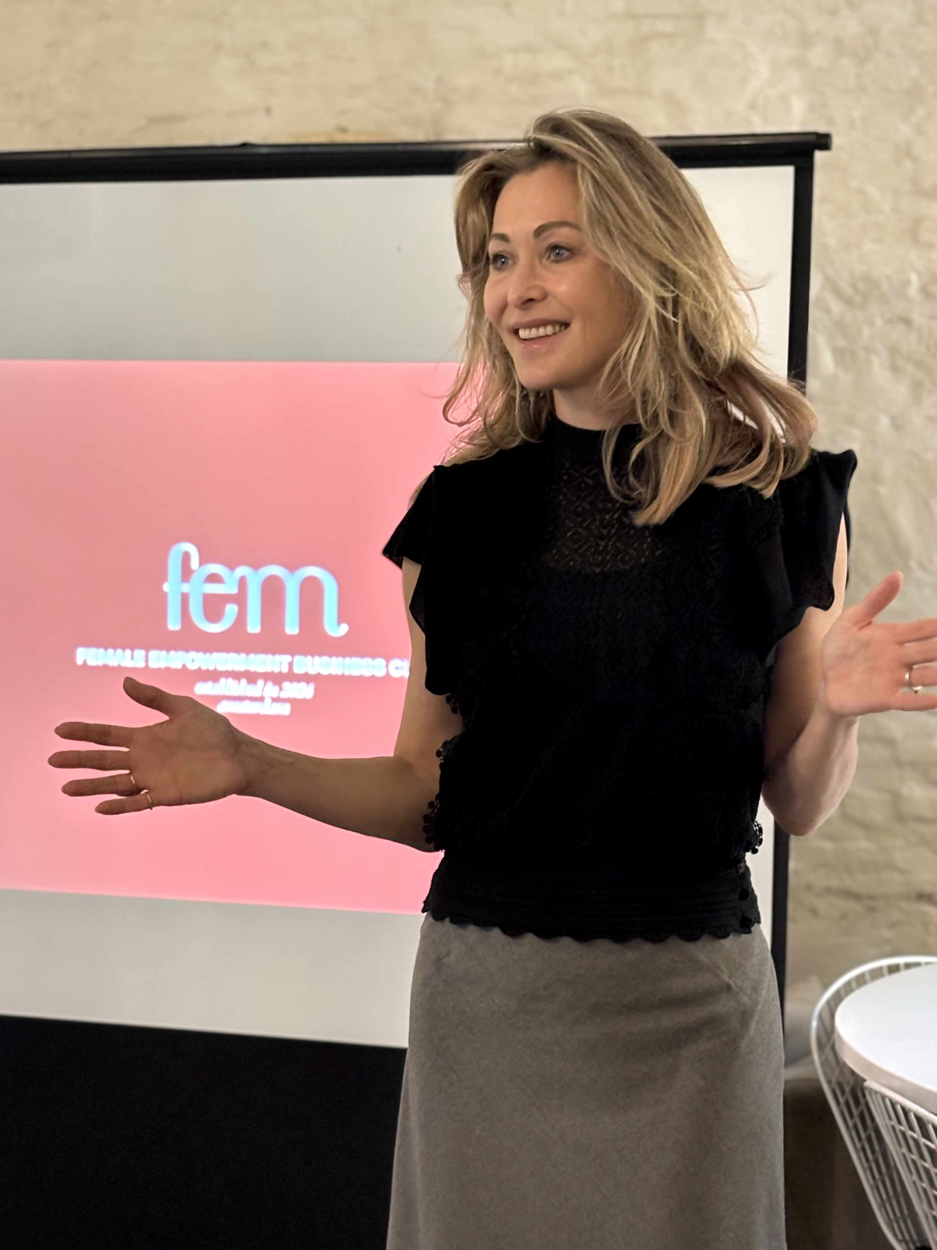 Sandra presenteert bij FEM Business Club met roze FEM banner